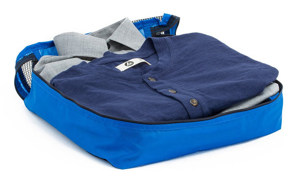 A few button-down shirts folded in an open Island (blue) Large Aether Aeronaut 45 Packing Cube.